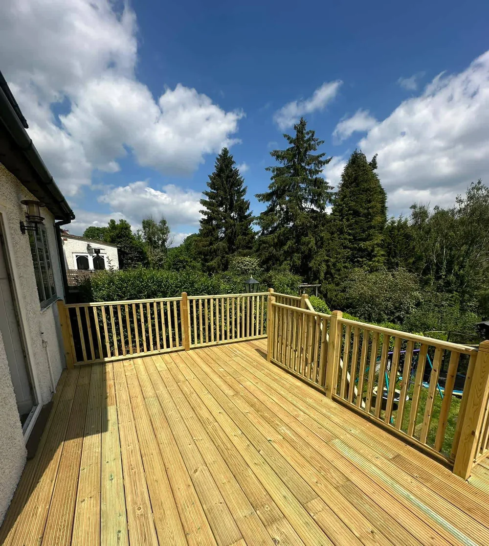Softwood deck with a spindle balustrade built out over a sloping garden