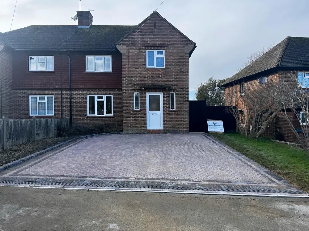 Grey block paved driveway laid in front of a red brick semi