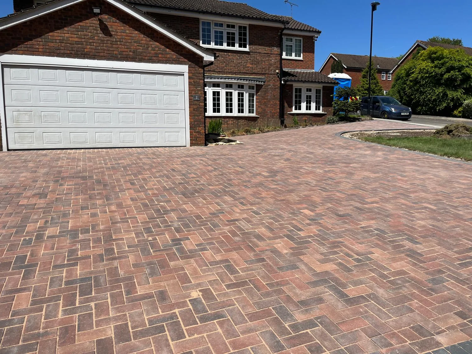 Brindle herringbone block paved driveway with charcoal edging in front of a double garage