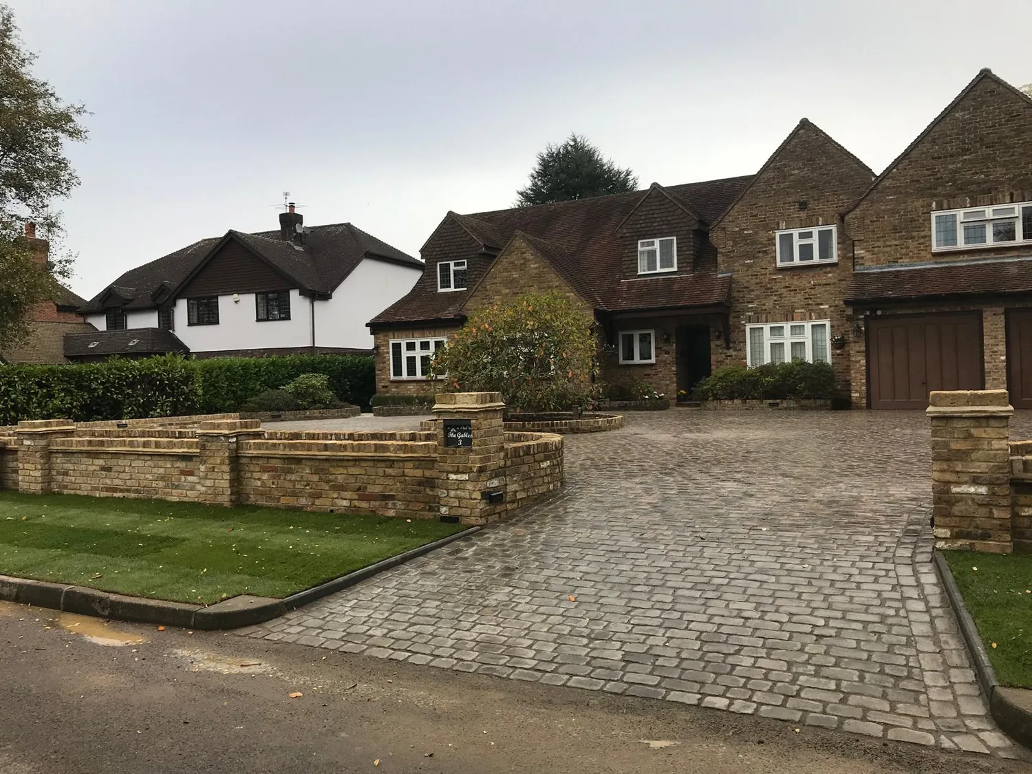 Charcoal block paved driveway laid to a tile hung house