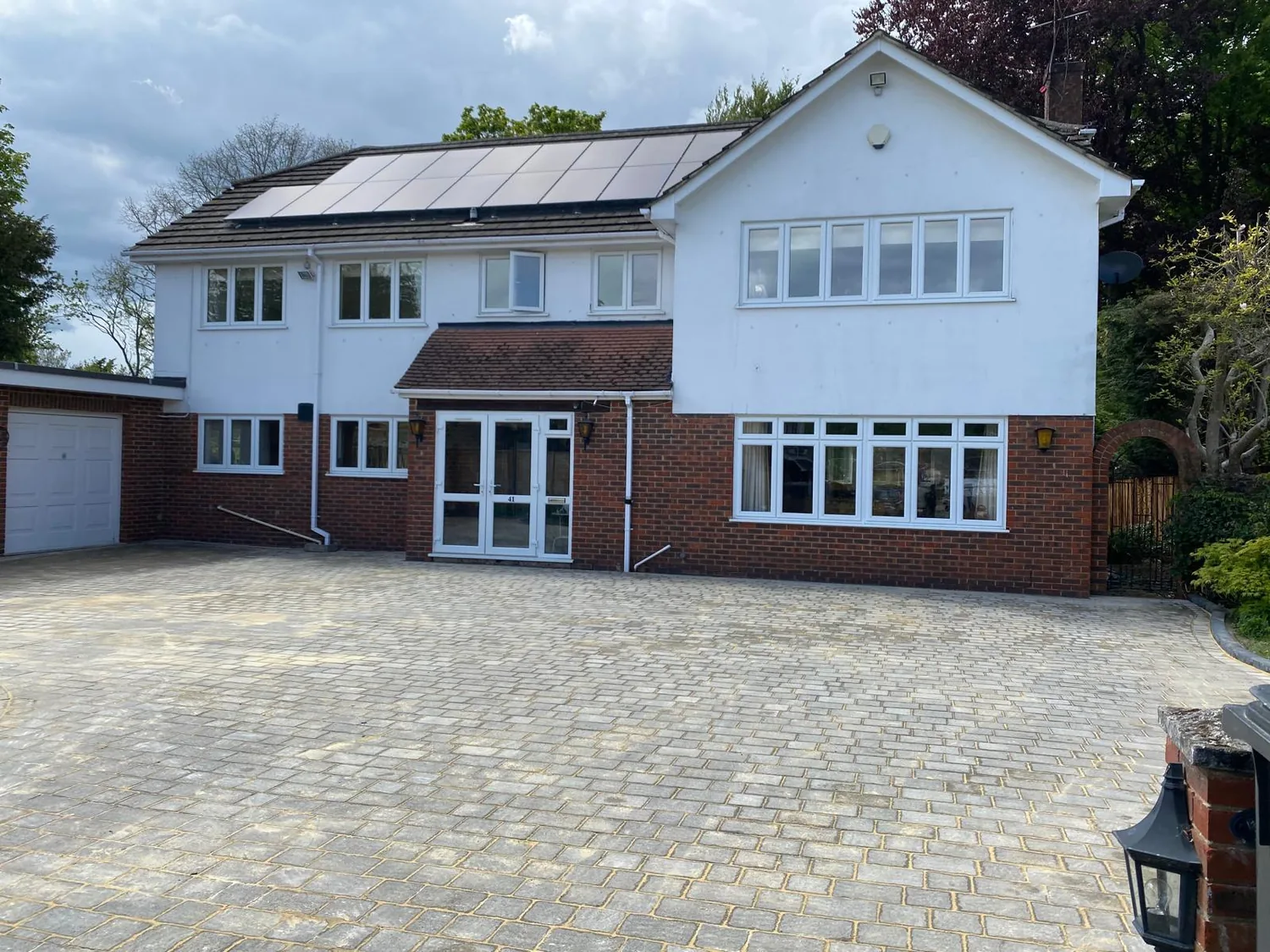 Sandstone paved path and drive laid to a white rendered house