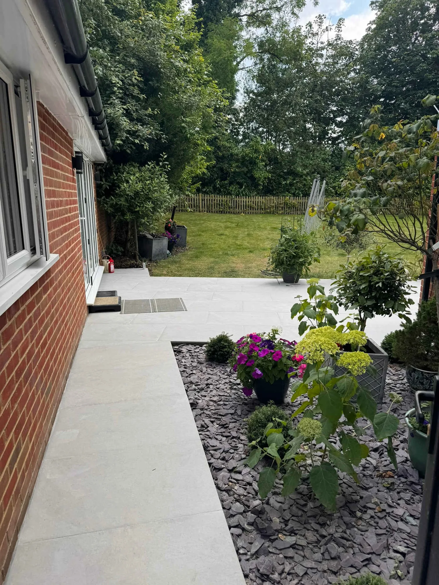 Porcelain garden path running between slate mulched beds and new planting
