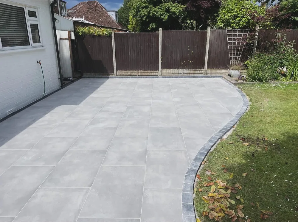 Curved porcelain patio sweeping round to a side gate