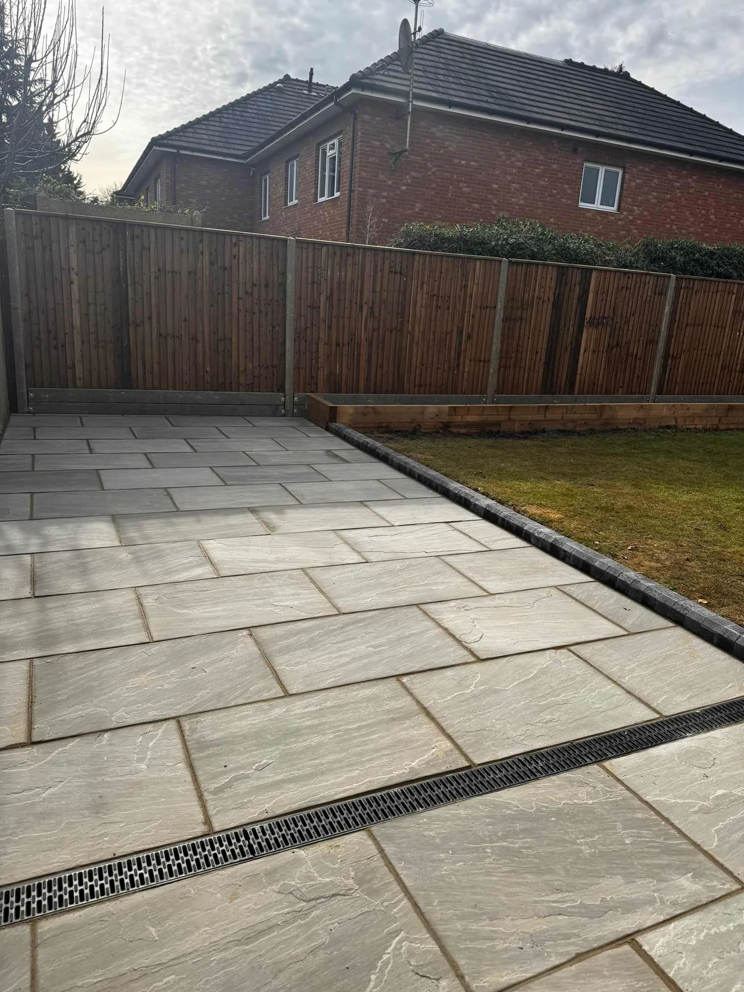 Riven paving with a linear drainage channel run along the edge