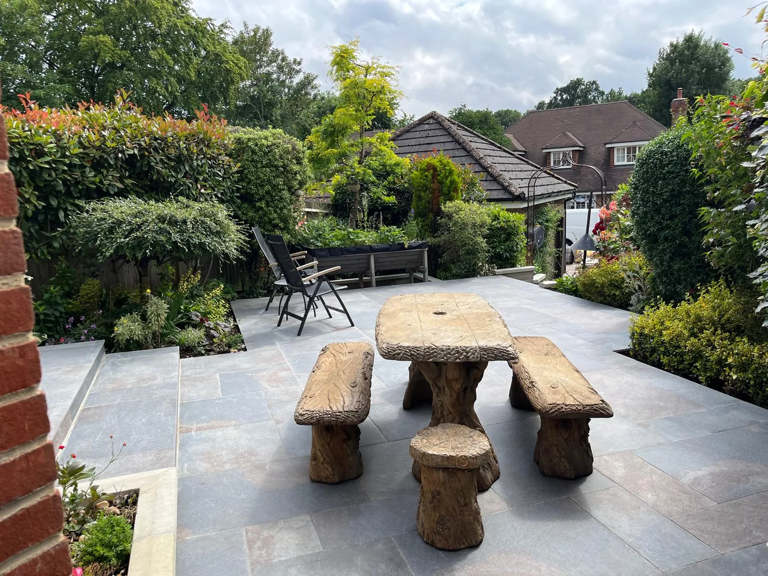 Porcelain paving laid up to a brick arch with a garden table set out on it