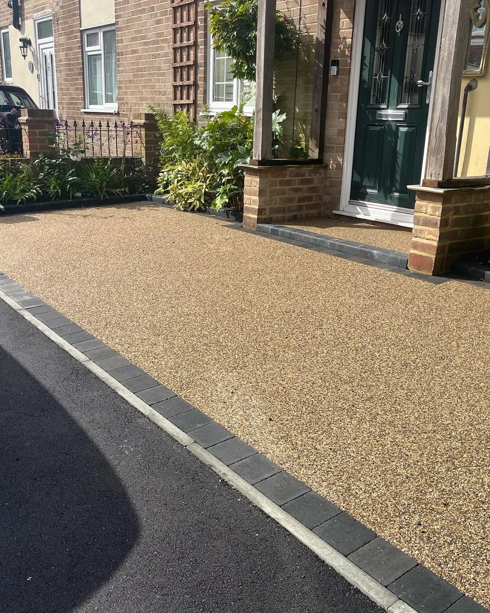 Golden resin-bound driveway with charcoal block edging leading to a brick porch and front door